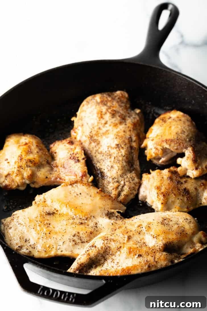 Creamy Mushroom Chicken Delight 6 Four perfectly seared chicken breast cutlets resting in a cast iron skillet.