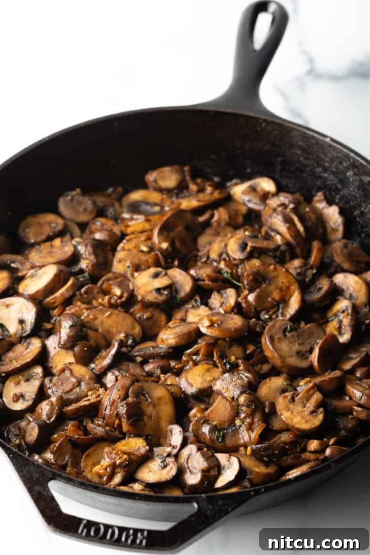 Creamy Mushroom Chicken Delight 9 Perfectly browned and softened cooked mushrooms in a cast iron skillet, ready for sauce.