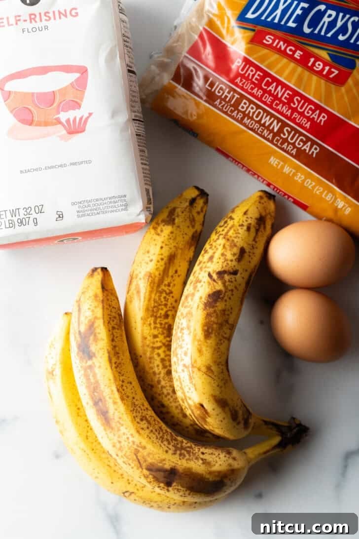 Effortless Banana Bread 5 Top-down view of all the essential recipe ingredients: a bunch of perfectly ripe bananas, a bag of self-rising flour, a bowl of light brown sugar, and two fresh eggs.