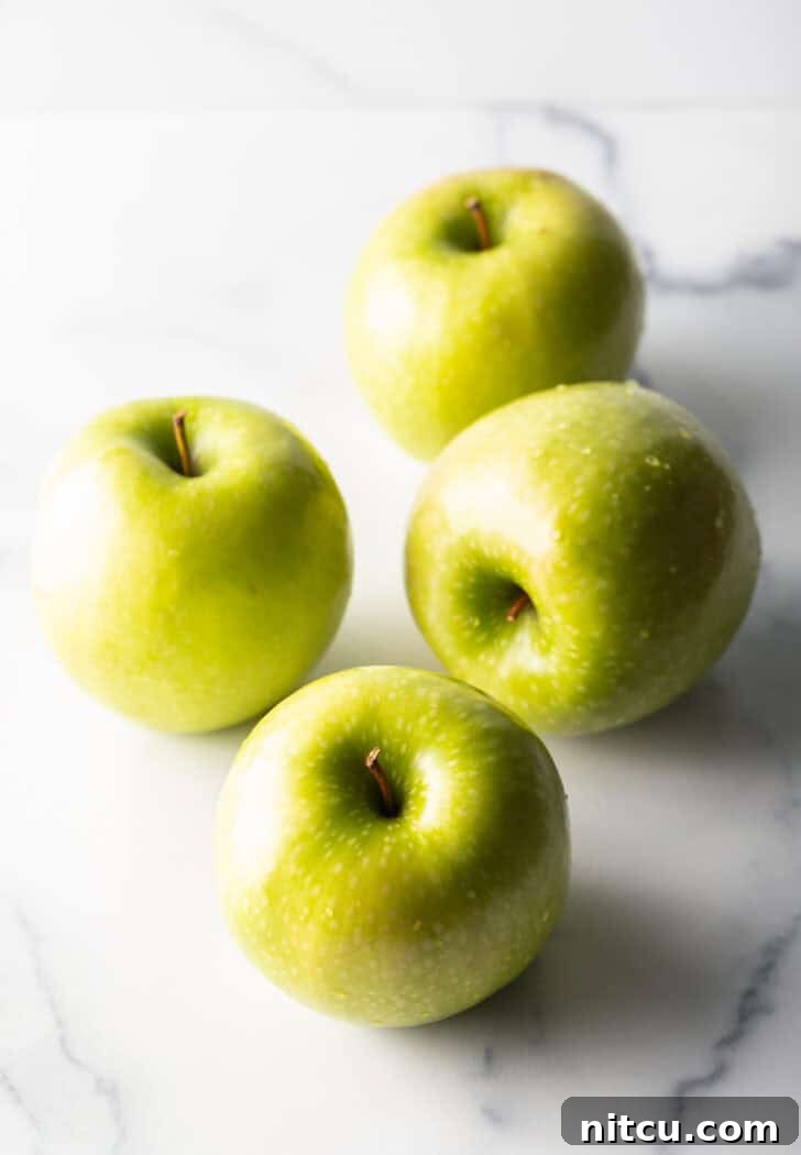 Caramelized Apple Bliss 6 Four whole Granny Smith apples, fresh and ready for preparation.