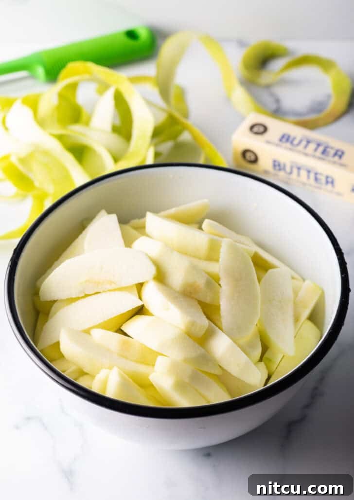 Caramelized Apple Bliss 7 A white bowl filled with freshly sliced apple wedges, coated in lemon juice.