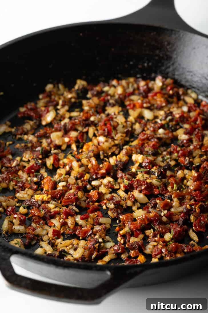 Cooking tomatoes, garlic and onion in a cast iron skillet.