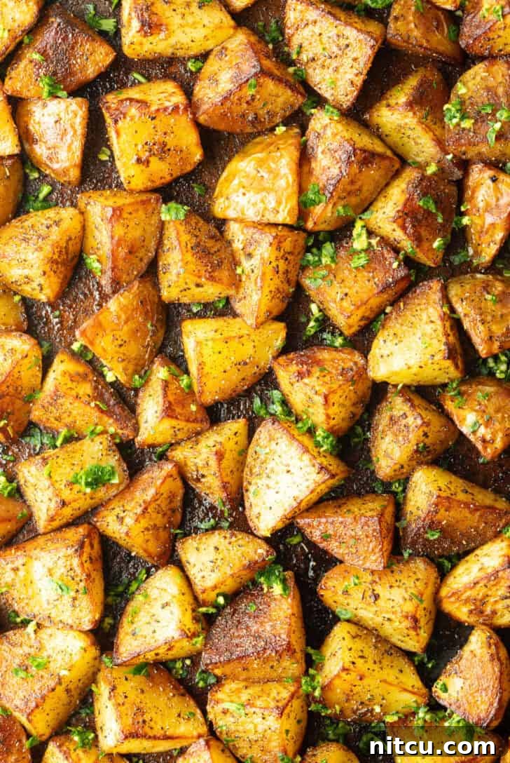 Crispy Potato Gold 4 Top down view a rimmed baking sheet covered with chunks of crispy golden potatoes.
