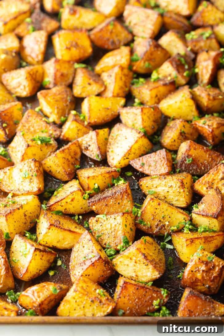 Crispy Potato Gold 9 Top down view a rimmed baking sheet covered with chunks of crispy golden potatoes.