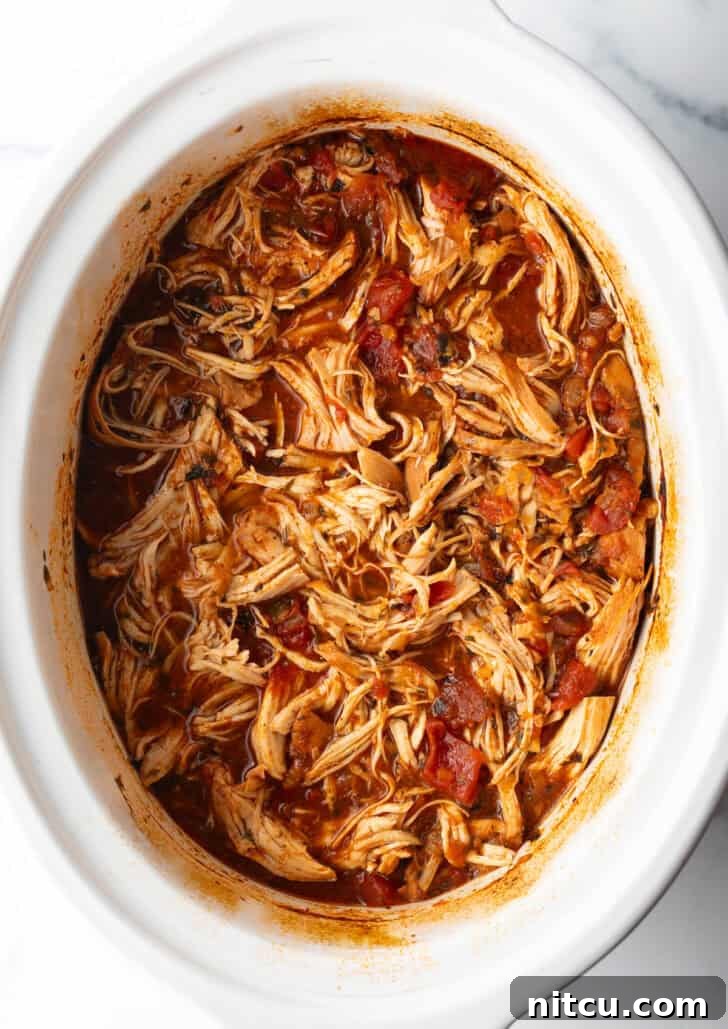Fiesta Slow Cooker Chicken 4 Top down view shredded Mexican chicken in a crockpot.