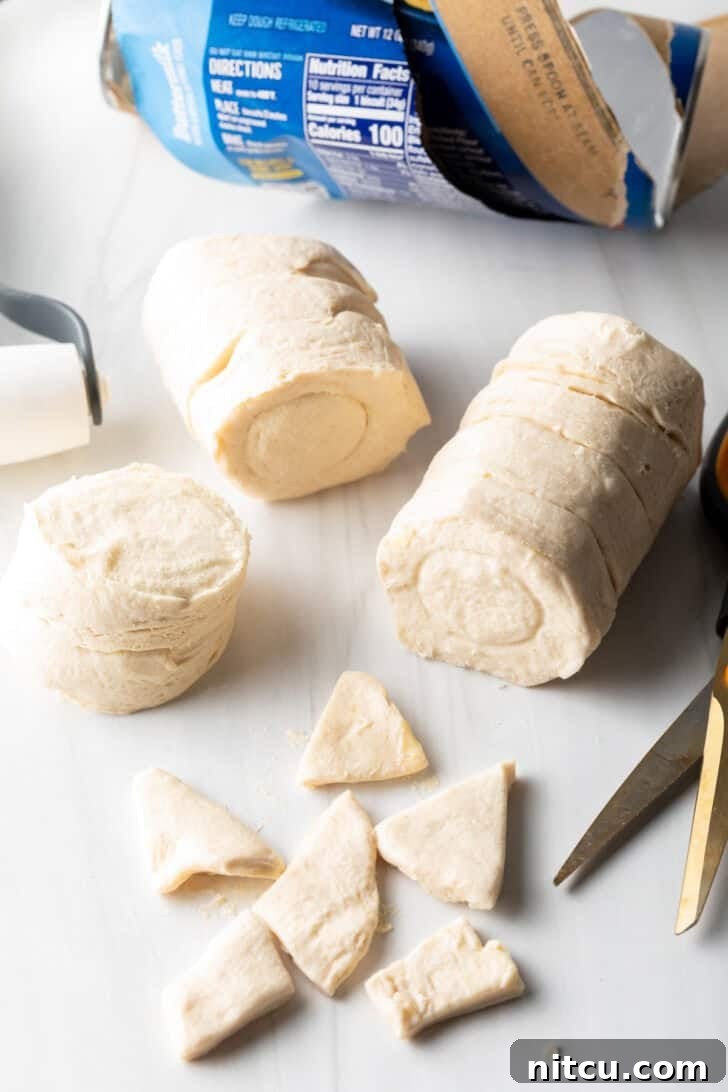 Effortless Slow Cooker Chicken and Dumplings 10 Small, triangular pieces of biscuit dough neatly arranged, cut from flattened biscuits, ready to be added to the slow cooker.