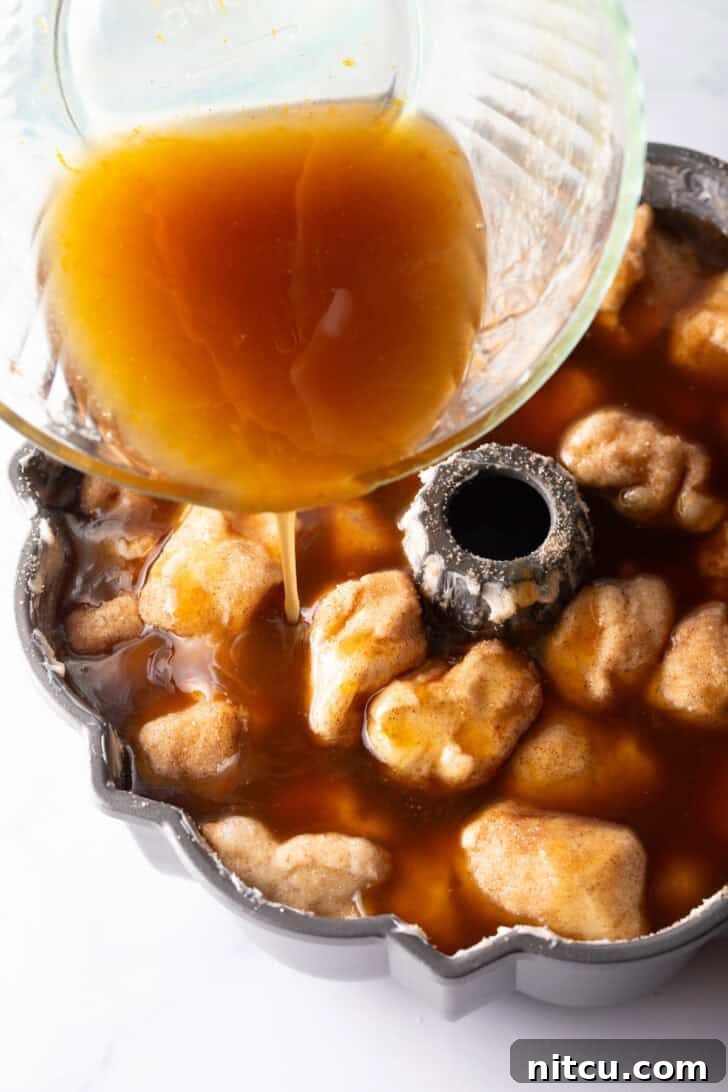 Irresistible Monkey Bread Delight 12 Bourbon syrup poured into the bundt pan with dough balls.