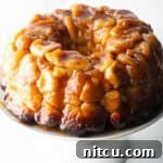 Monkey bread baked in a bundt pan, plated on a white cake stand.