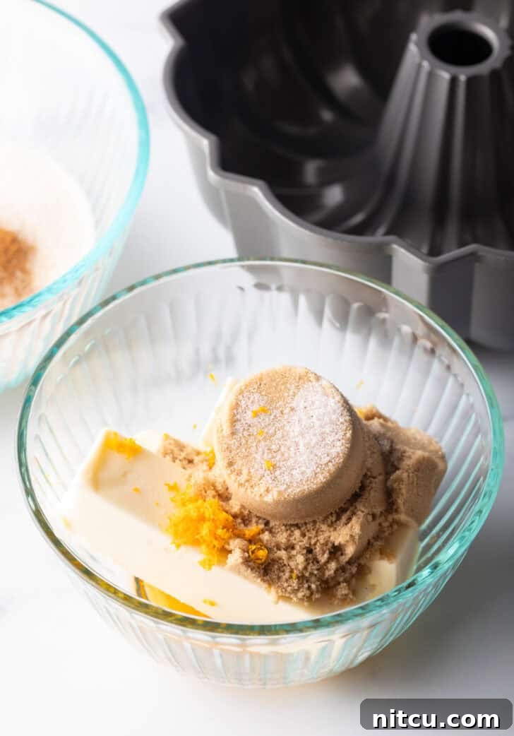 Irresistible Monkey Bread Delight 9 Glass bowl with brown sugar, orange zest, butter, and pumpkin pie spice.