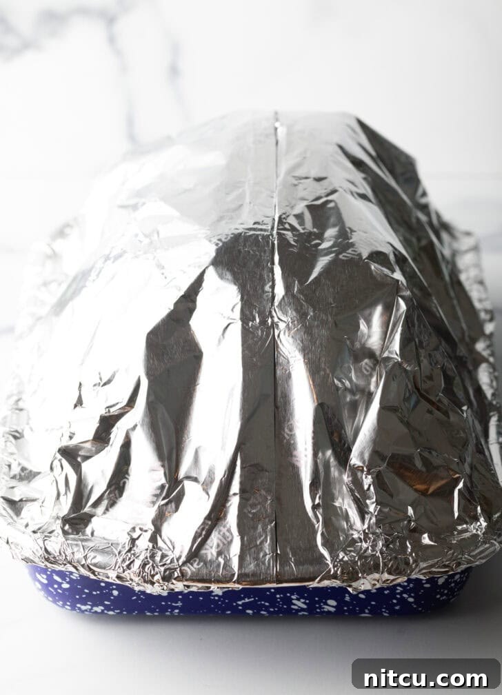 Perfect Spiral Ham Recipe 6 Ham and pan tightly wrapped in aluminum foil, ready for the oven to ensure moisture is retained.