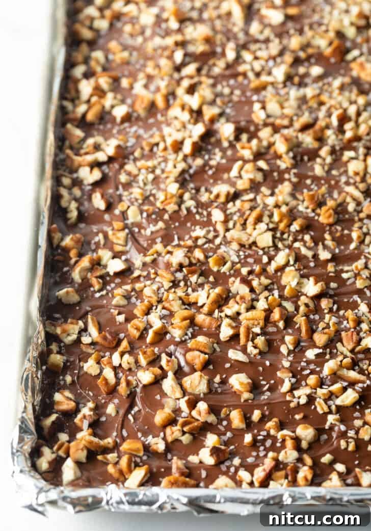 Rimmed baking sheet with chocolate and broken pieces of toffee.