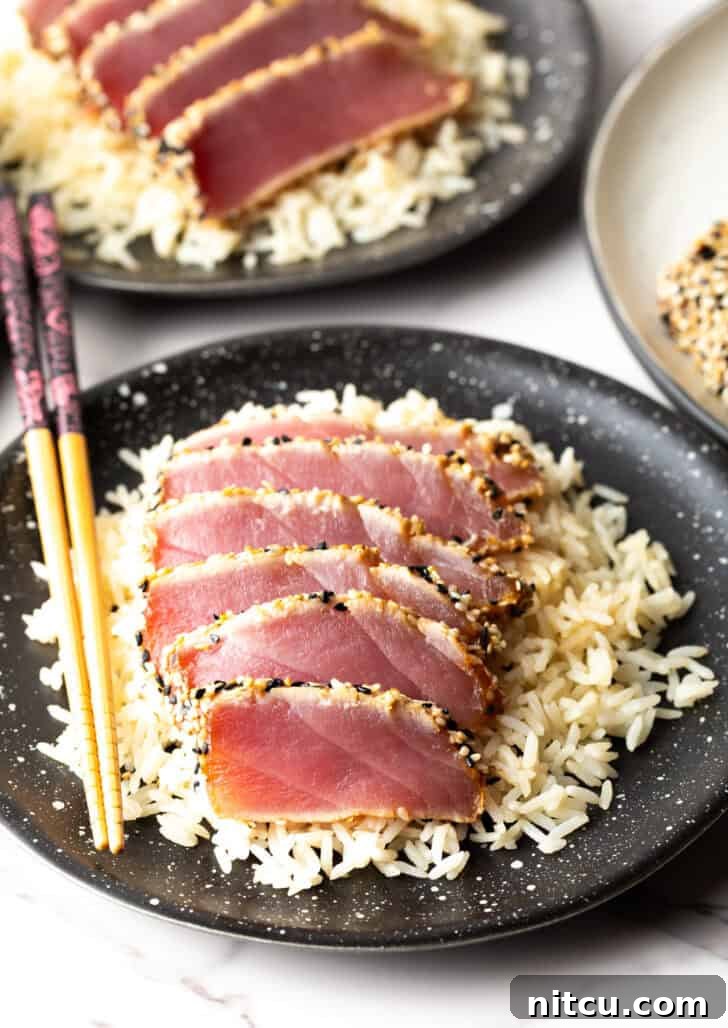 Flash-Seared Ahi Tuna 14 Top-down view of six slices of beautifully seared ahi tuna on a bed of white rice, ready to be enjoyed.
