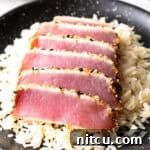 Flash-Seared Ahi Tuna 15 Six slices of seared ahi tuna on a bed of white rice.