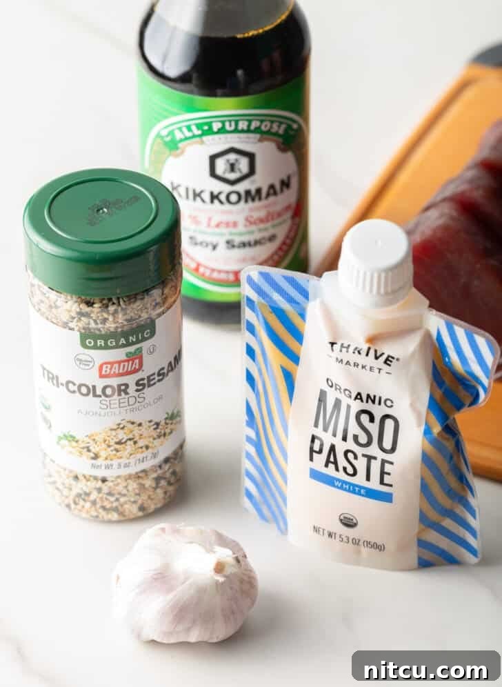 Flash-Seared Ahi Tuna 5 Ingredients for yellowfin marinade: Jar of tricolor sesame seeds, bottle of low-sodium soy sauce, a whole bulb of garlic, and a squeeze pack of white miso paste.