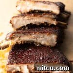 Gateway City Ribs 14 St. Louis style ribs stacked on top of each other on cutting board.