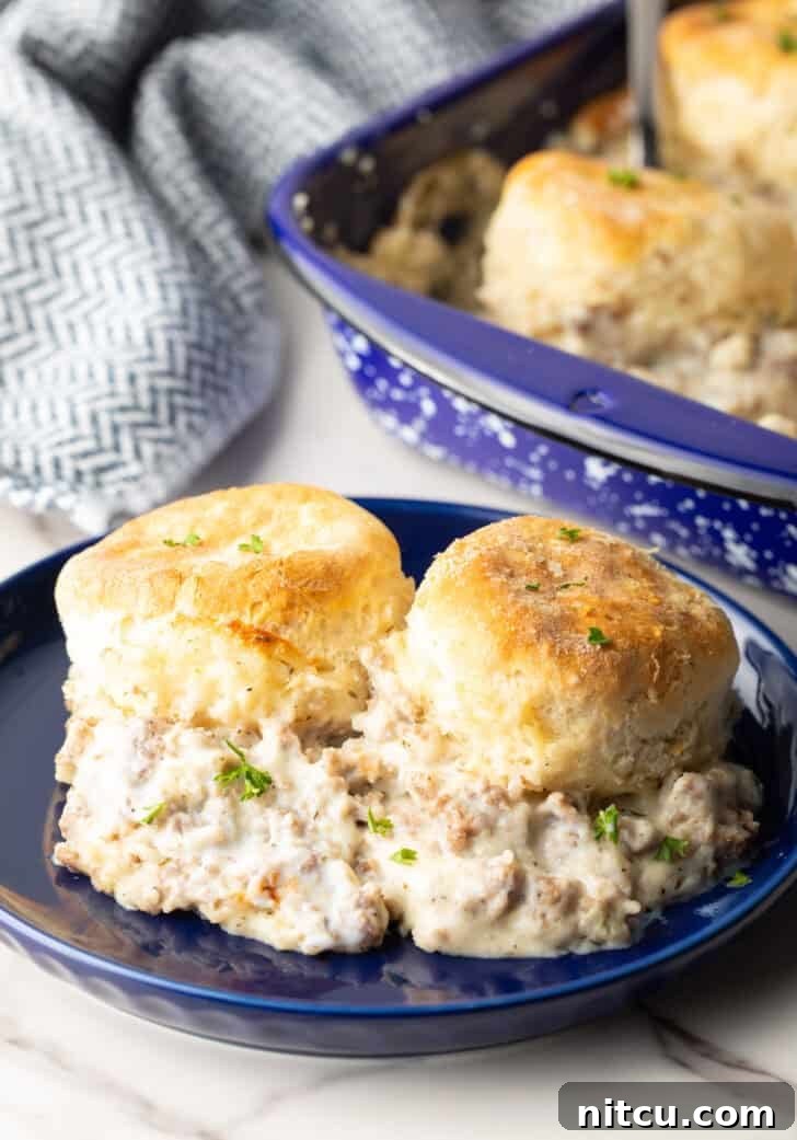 Two servings of biscuits and gravy on a blue plate, ready to be enjoyed.