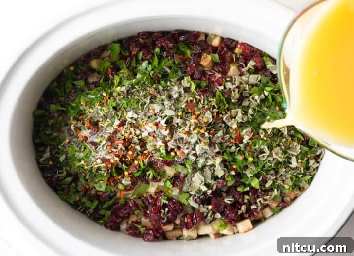 Effortless Crock Pot Stuffing 8 Broth pouring over slow cooker stuffing recipe before cooking.