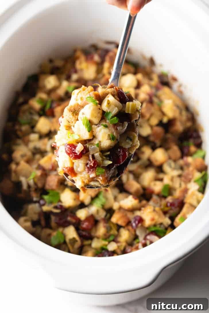 Effortless Crock Pot Stuffing 10 A scoop of crock pot stuffing being held with a metal spoon.
