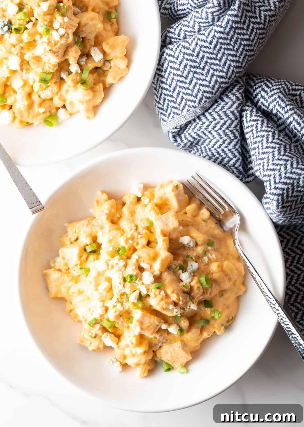 Top down view of white bowl of creamy cheesy buffalo chicken mac n cheese.