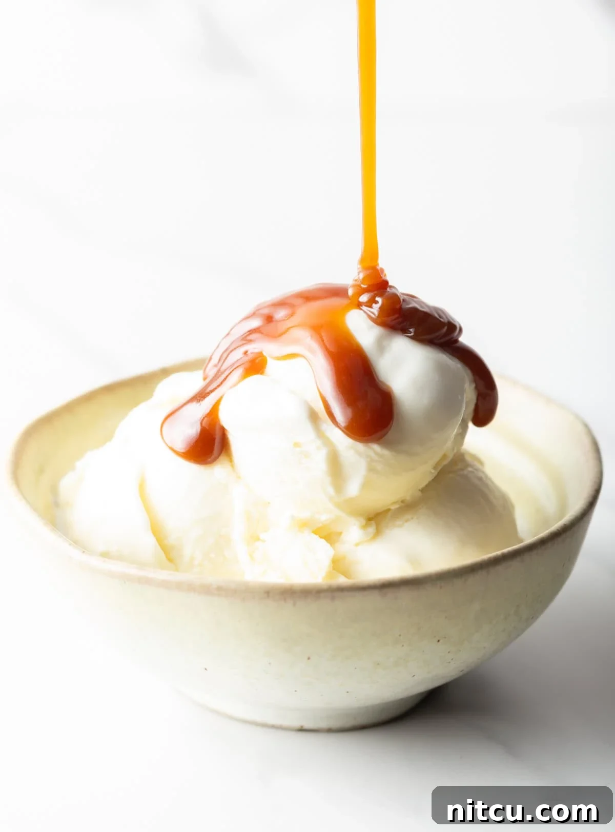 Salted Caramel Delight 10 Salted caramel being drizzled over vanilla ice cream in a white bowl.