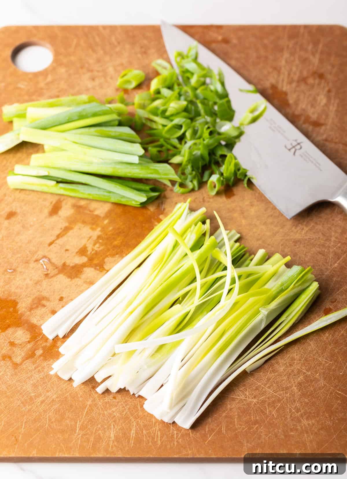 Effortless Udon Bowl 6 Chopped green onions on a cutting board next to a knife.