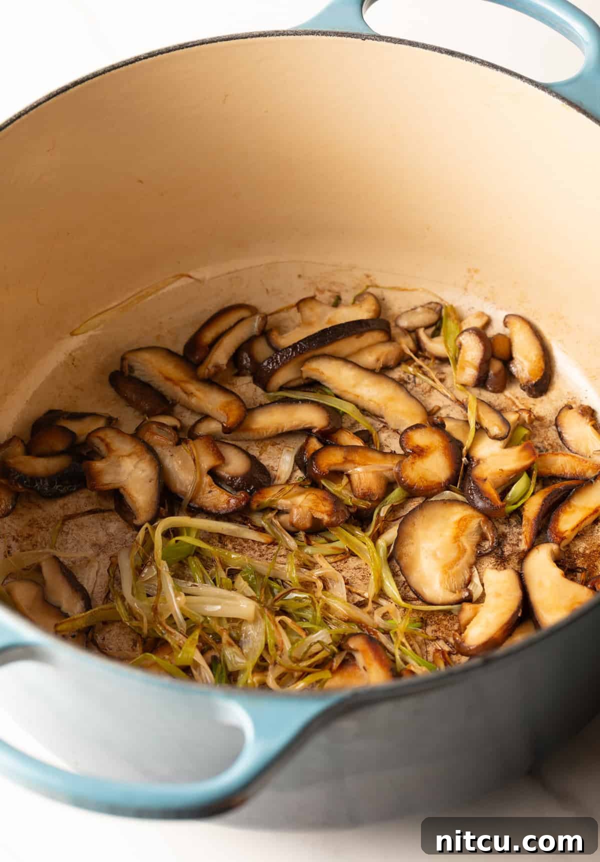 Effortless Udon Bowl 7 Pot of shiitake mushrooms and green onions after being stir-fried.