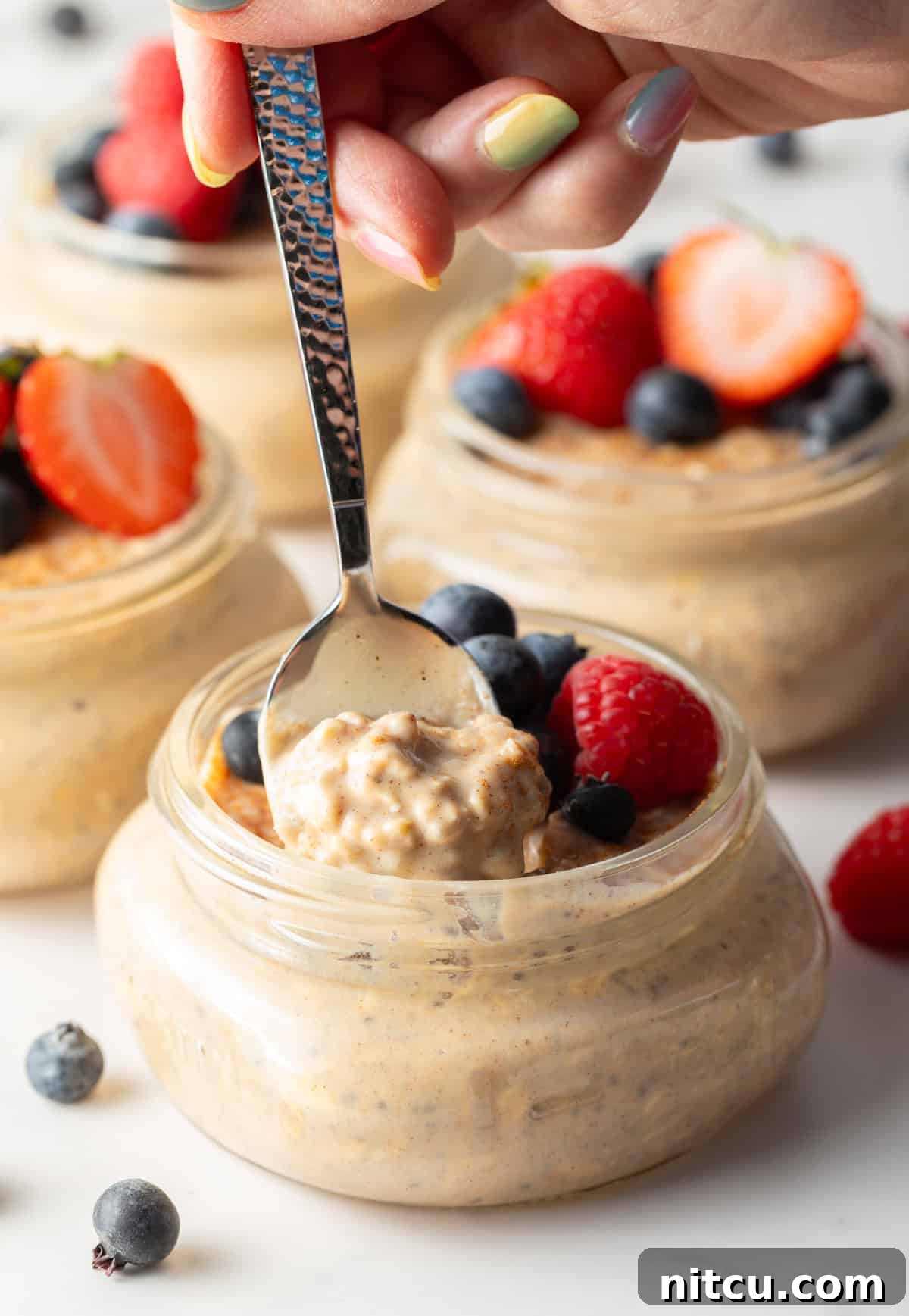 Protein Packed Next-Day Oats 5 A spoon taking a bite out of a jar of high protein oatmeal.