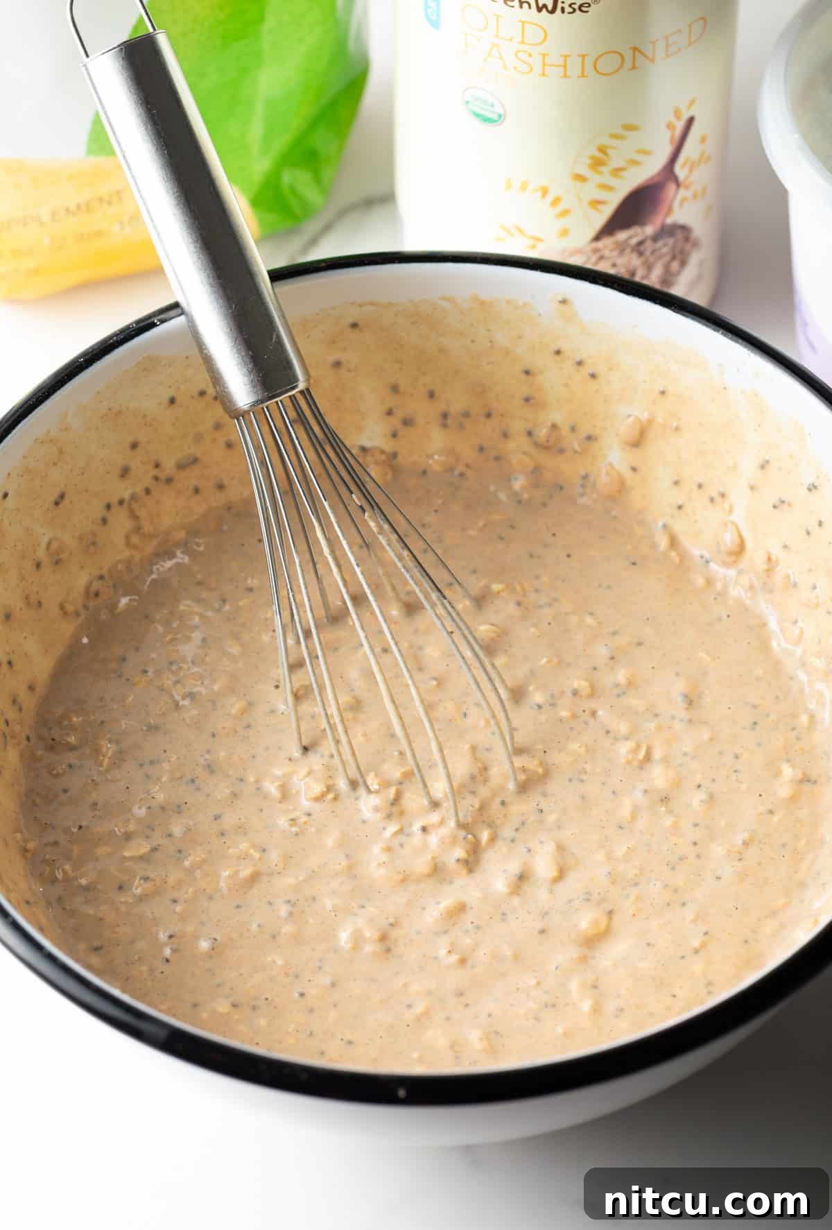 Protein Packed Next-Day Oats 8 A whisk stirring all ingredients for high protein overnight oats.