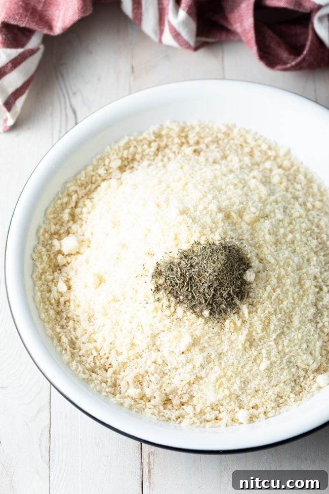 Golden Baked Chicken Cutlets 7 Closeup of ingredients for breadcrumb mixture in a bowl, including panko and parmesan.
