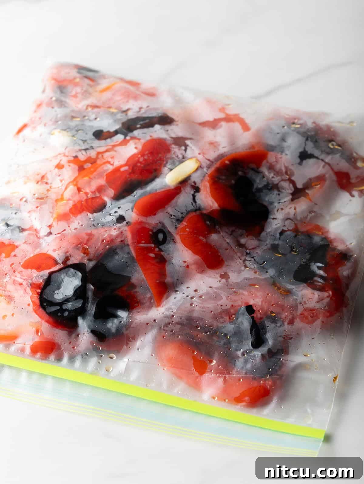 Smoky Red Pepper Bisque 7 Charred red bell peppers captured inside a clear ziplock bag, steaming to loosen their skins for easy peeling, a crucial step for creamy roasted red pepper soup.
