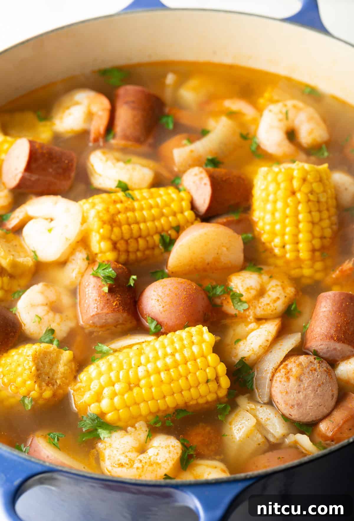 Coastal Bounty Boil 9 The fully cooked Low Country Boil, a harmonious mix of perfectly cooked shrimp, tender potatoes, sweet corn, and savory sausage, beautifully seasoned with Old Bay, ready to be served.