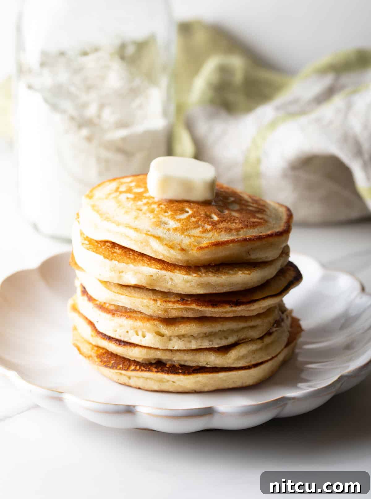 A fluffy stack of pancakes with butter on top, made with a homemade pancake mix recipe.