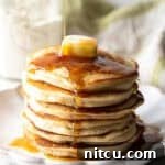 A fluffy stack of pancakes with butter and syrup, made with a homemade pancake mix recipe.