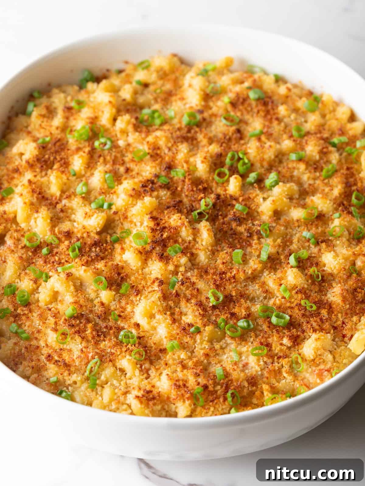 Big Easy Mac and Cheese 11 Golden and crispy baked New Orleans mac and cheese in a white baking dish.
