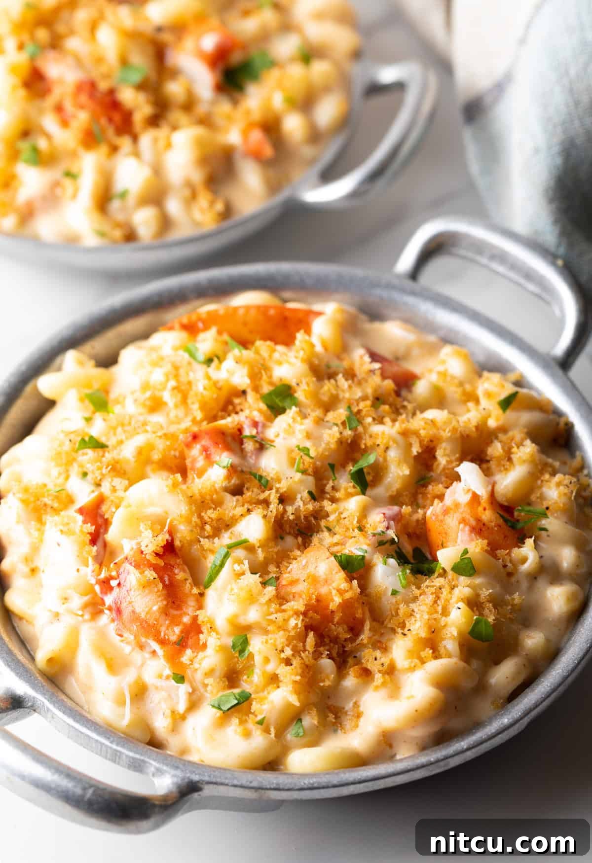 Decadent Lobster Mac and Cheese 12 A metal bowl filled with creamy lobster mac and cheese.