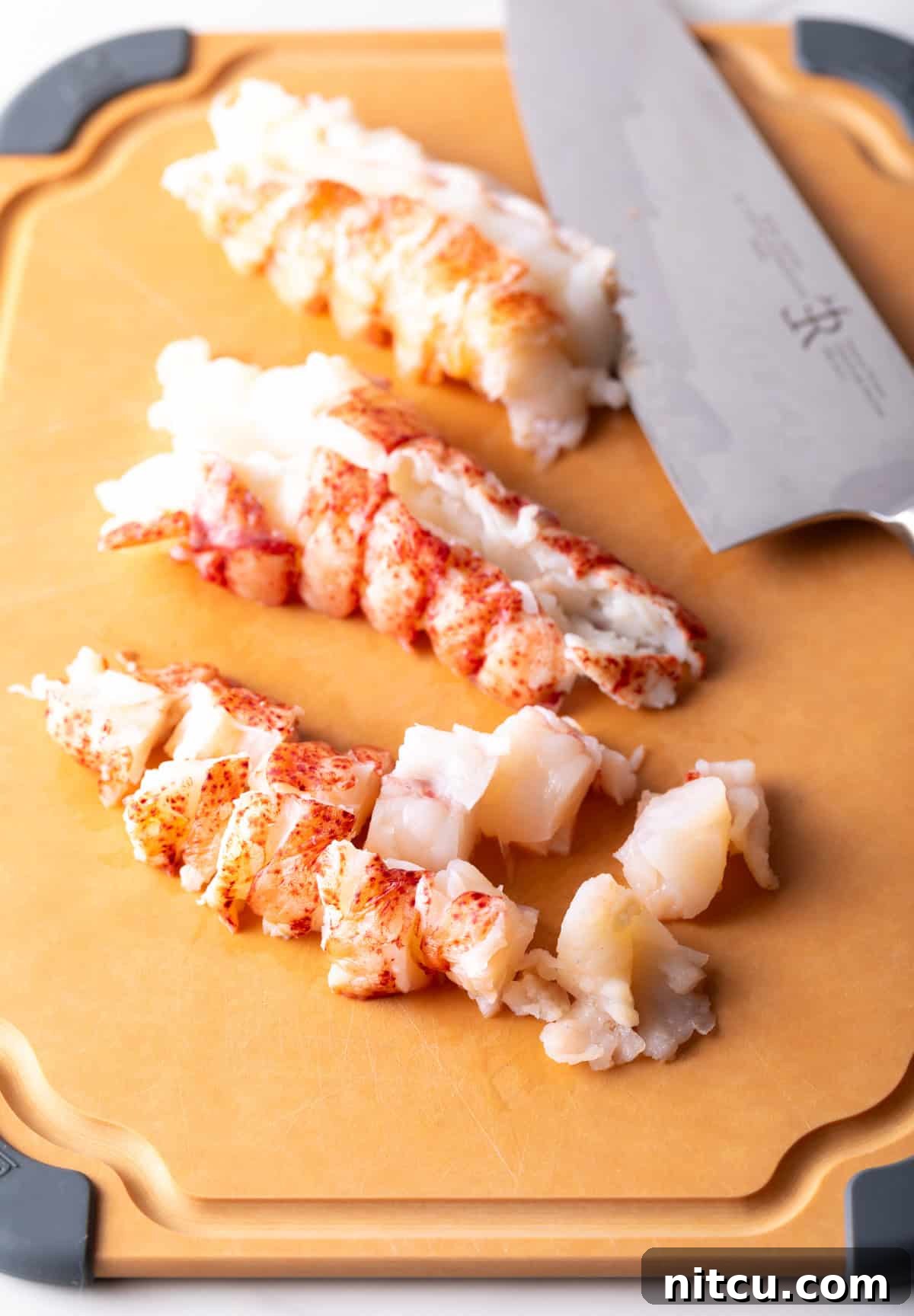 Decadent Lobster Mac and Cheese 6 Cooked lobster on a cutting board that is chopped into bite sized pieces for lobster mac and cheese.