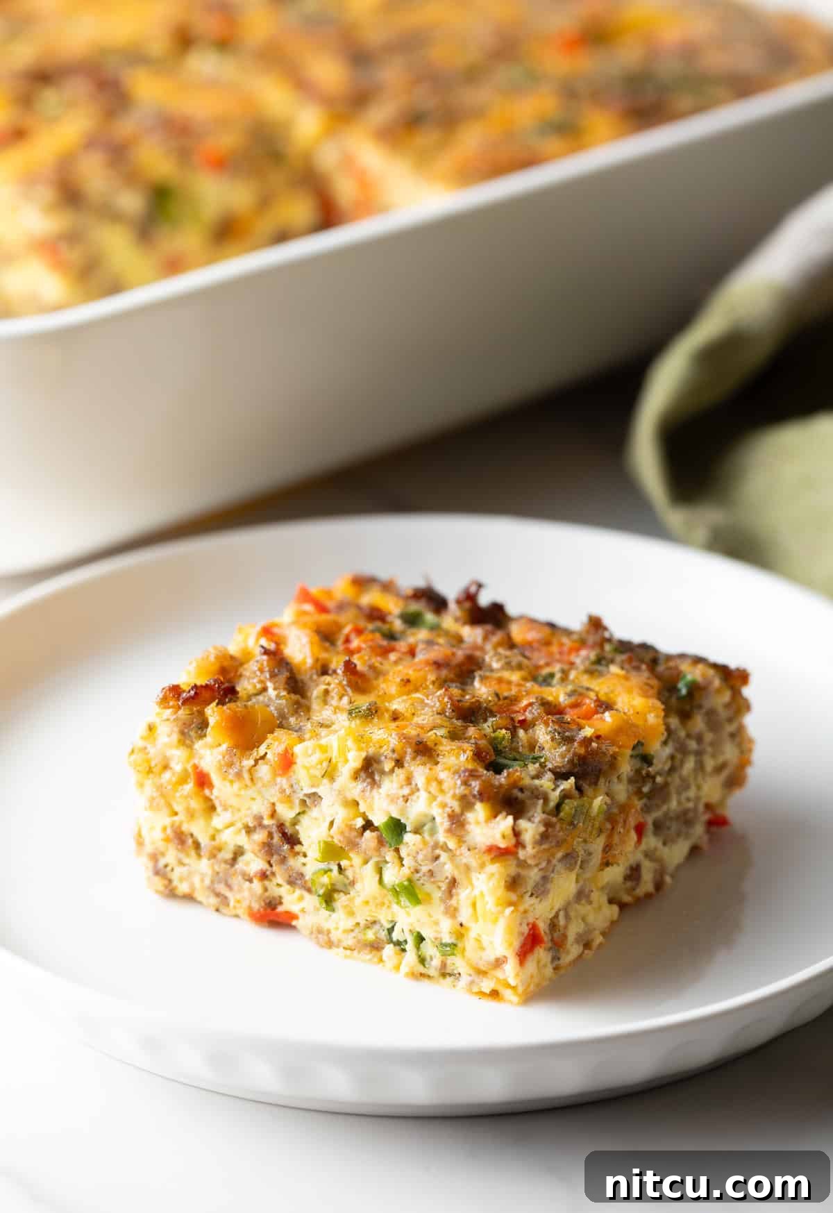 Savory Morning Sausage Bake 5 Square of sausage breakfast casserole on a white plate.