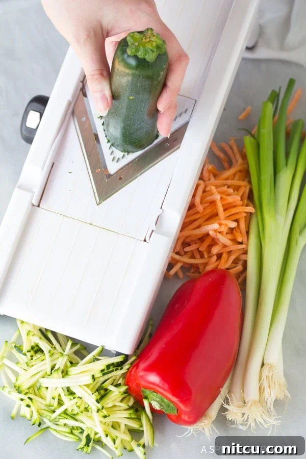 Sizzling Korean Jeon 3 A hand is expertly using a mandolin slicer to prepare the fresh vegetables, ensuring thin, uniform strips perfect for Korean Pajun pancakes.