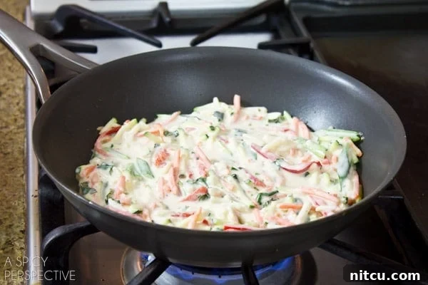 Sizzling Korean Jeon 6 Several Korean pancakes (Pajeon) are shown sizzling and frying in a hot pan, their edges turning golden-brown, promising a delicious crispiness.
