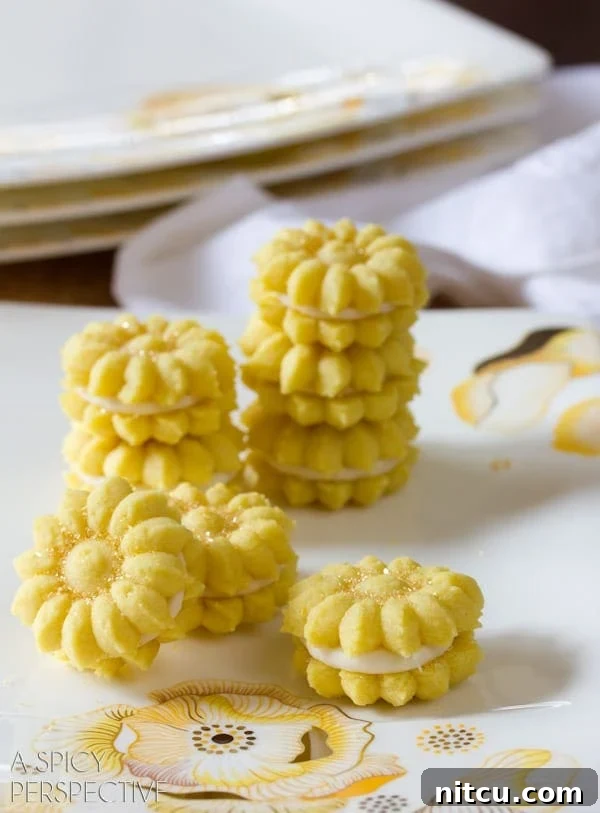 Zesty Lemon Spritz Delights 4 Lemon Cookies with Lemon Cream Filling - Spritz Cookies stacked on plate