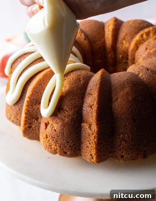 Luscious Peach Bundt Cake 7 Detailed close-up of the peach bundt cake, showcasing the smooth, sweet glaze dripping down its sides.