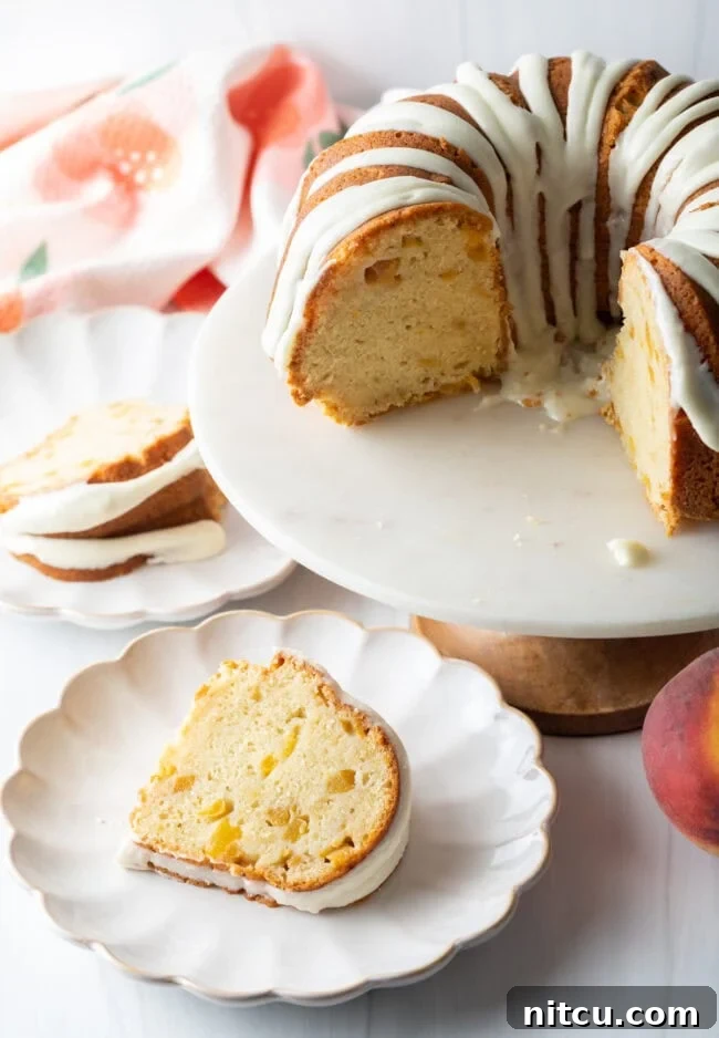 Luscious Peach Bundt Cake 9 A freshly cut slice of Peaches and Cream Bundt Cake resting on a plate, showing its moist interior.