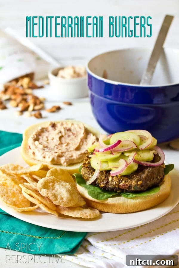 Signature Mediterranean Burger 2 A perfectly cooked Mediterranean burger, garnished with fresh herbs and served on a toasted bun with a side of crispy chips.