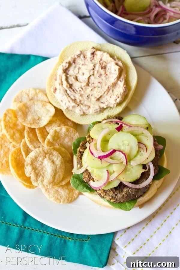Signature Mediterranean Burger 9 An overhead view of a plated Mediterranean burger, elegantly presented with a side of chips on a rustic surface.
