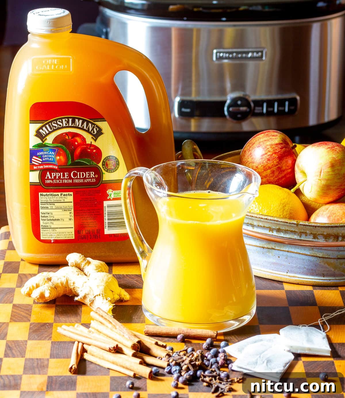 mulled-drink Ingredients needed to make wassail recipe with a crockpot in the background.