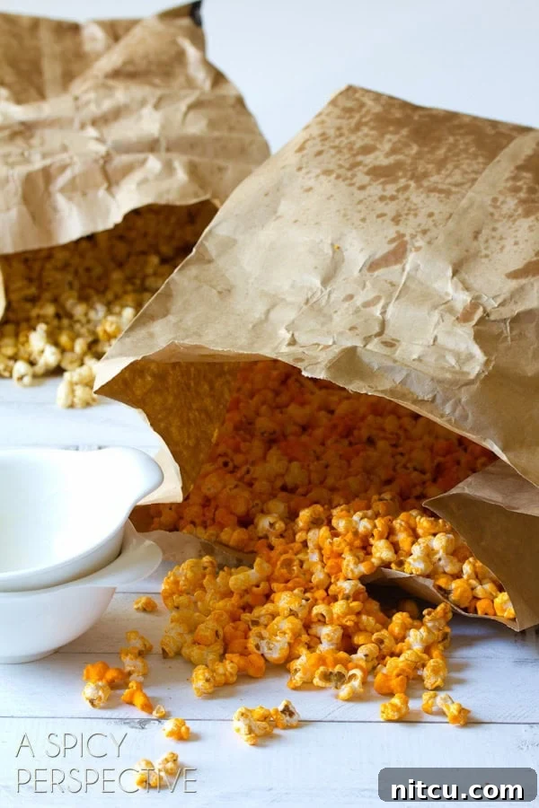 Mastering Garretts Famous Popcorn 5 Two paper bags, one filled with caramel popcorn and the other filled with cheese popcorn.