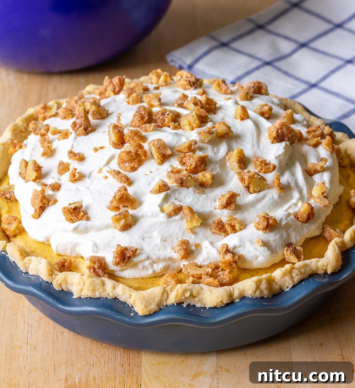Cream-Pie Close-up of a Pumpkin Cream Pie with a thick layer of pumpkin filling and a generous swirl of whipped cream on top