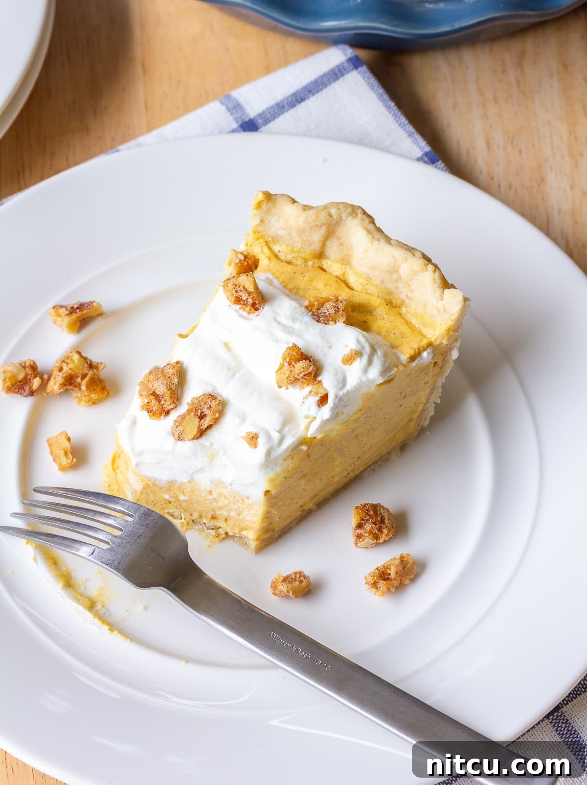 Dessert-Time A perfect slice of pumpkin cream pie on a white plate, garnished with candied nuts.