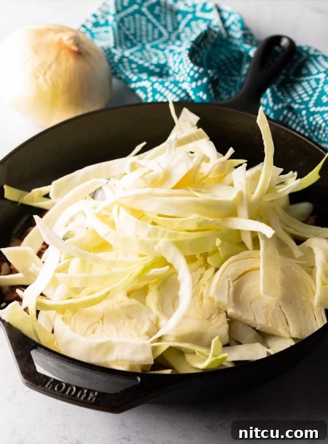 Adding garlic to the fragrant cabbage and onion mixture for Haluski
