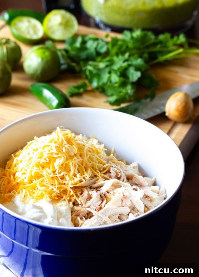 A bowl filled with the creamy, shredded chicken enchilada filling.
